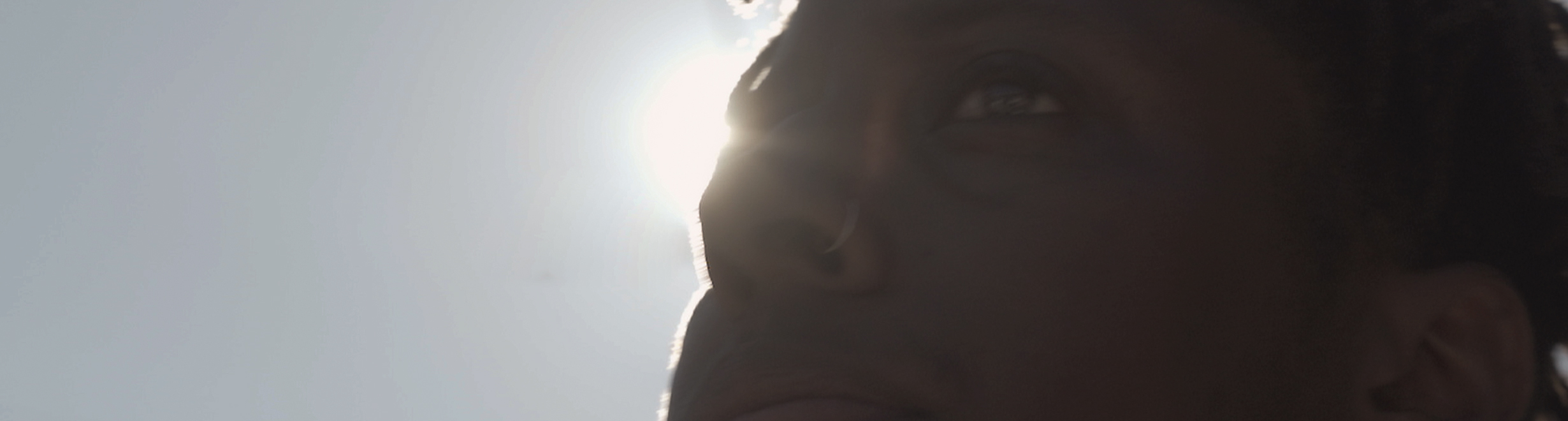 Young person outside with the sun in the background