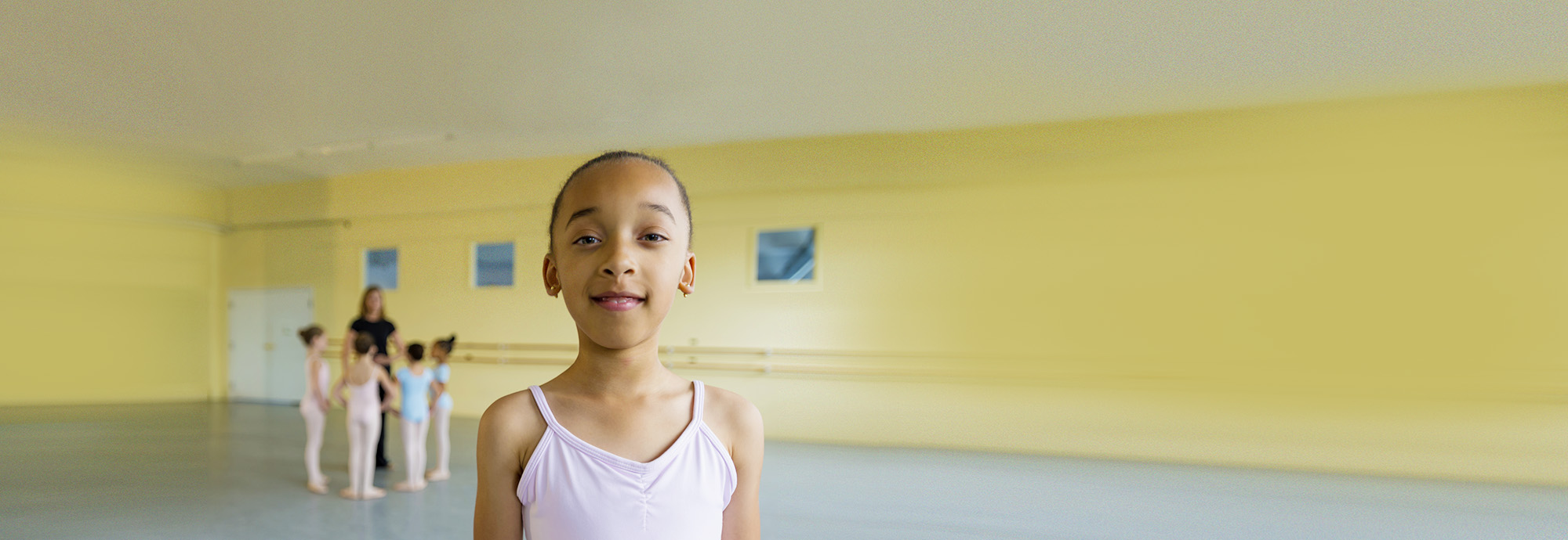 A young person looking at the camera during a dance class