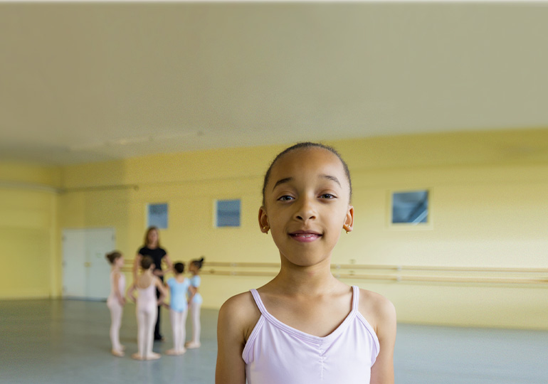 A young person looking at the camera during a dance class