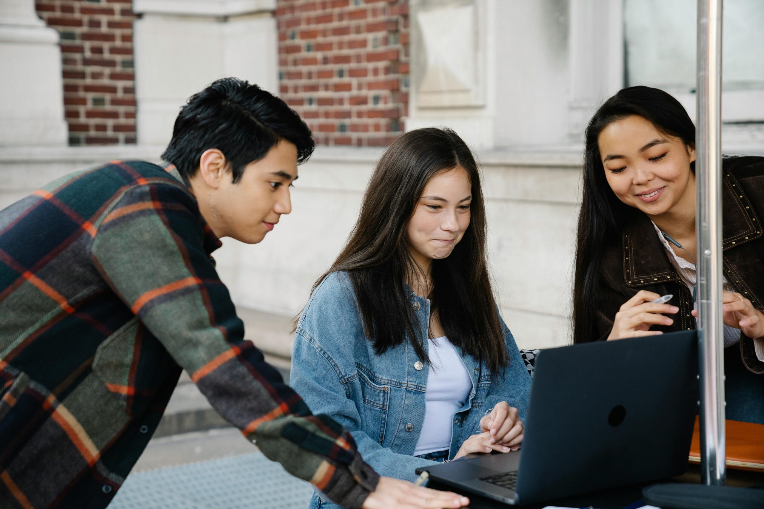 A group of young people using a laptop to connect with other youth on the KHP Peer-to-Peer community