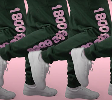 Image of a person's legs, wearing green sweatpants with pink printing on the side